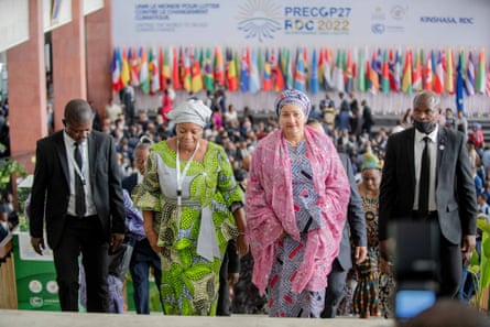 Two women in traditional African robes flanked by two men in suits at a convention centre