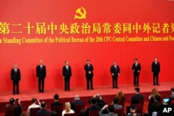 FILE - New members of the Politburo Standing Committee, from left, Li Xi, Cai Qi, Zhao Leji, President Xi Jinping, Li Qiang, Wang Huning, and Ding Xuexiang are introduced at the Great Hall of the People in Beijing, Oct. 23, 2022.