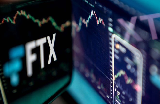 This photo illustration taken on November 13, 2022, shows the logo of cryptocurrency FTX, reflected in its website on a laptop screen in Washington, DC.