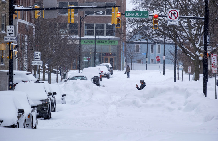 People move about the streets of the Elmwood Village neighborhood of Buffalo, N.Y. Monday, Dec. 26, 2022, after a massive snow storm blanketed the city. Along with drifts and travel bans, many streets were impassible due to abandoned vehicles.