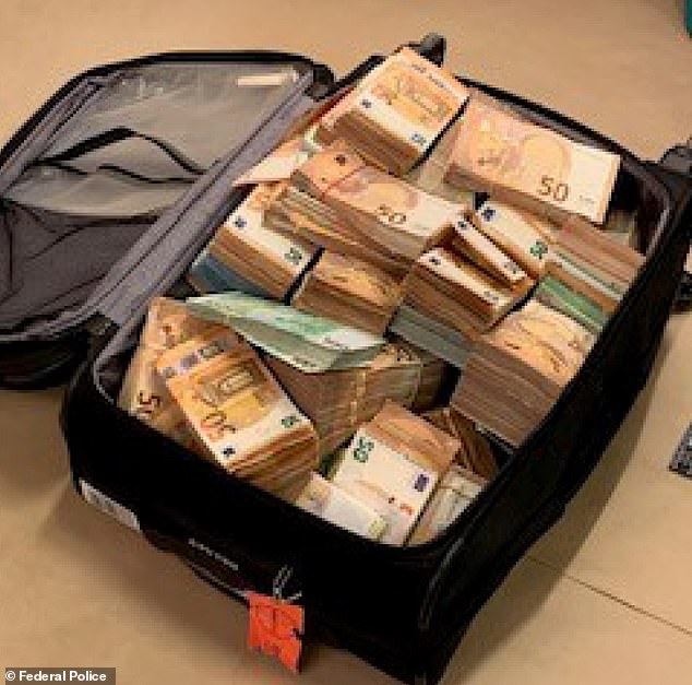 Belgian police have released a picture of euro notes worth £500,000 they discovered stuffed inside a suitcase in anti-corruption raids at the weekend