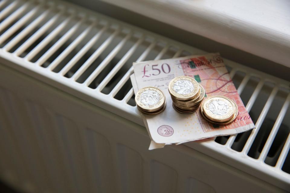 Consumer confidence Cost of living crisis. Money on a home radiator heater. Rising cost of energy and bills