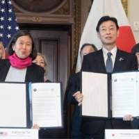 U.S. Trade Representative Katherine Tai and  Japan's visiting Minister of Economy, Trade and Industry, Yasutoshi Nishimura, hold up signed labor-standards memorandums at the White House in Washington on Friday. | KYODO