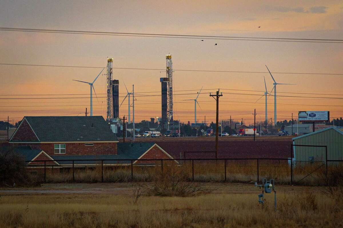 Drilling rigs and wind turbines visible near Interstate 20 in March 2022 in Stanton, Texas. MANDATORY CREDIT: The Oilfield Photographer, Inc.