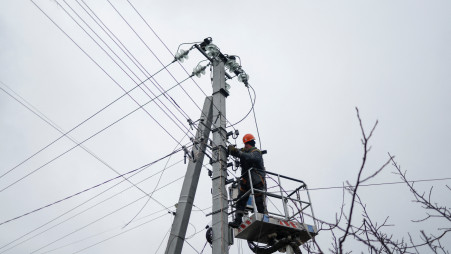 An employee of power supplier repairs power lines in front of residential houses damaged by a Russian military strike, amid Russia&#039;s attack on Ukraine, in the town of Hlevakha, outside Kyiv, Ukraine January 26, 2023. REUTERS/Valentyn Ogirenko