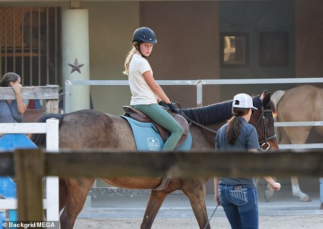 He started watching his daughter's lesson again soon after the agitated phone call, with the 10-year-old looking happy in the saddle
