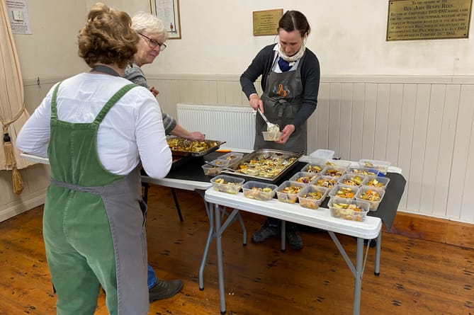 Volunteers packaging the cooked food in recyclable tupperware