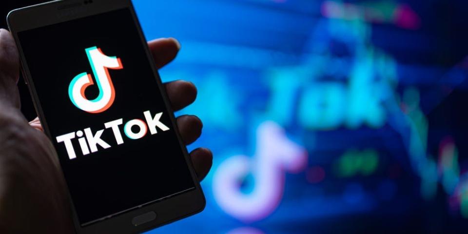 hand holding phone with TikTok logo