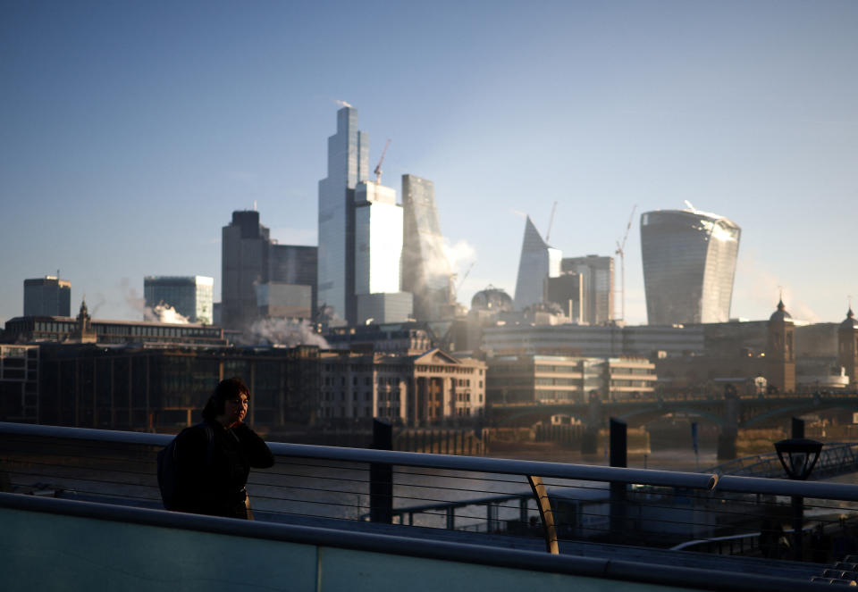 FTSE  A person walks over Millennium Bridge amidst early morning fog, as the sun rises beyond the City of London financial district in the background, in London, Britain, February 8, 2023. REUTERS/Henry Nicholls