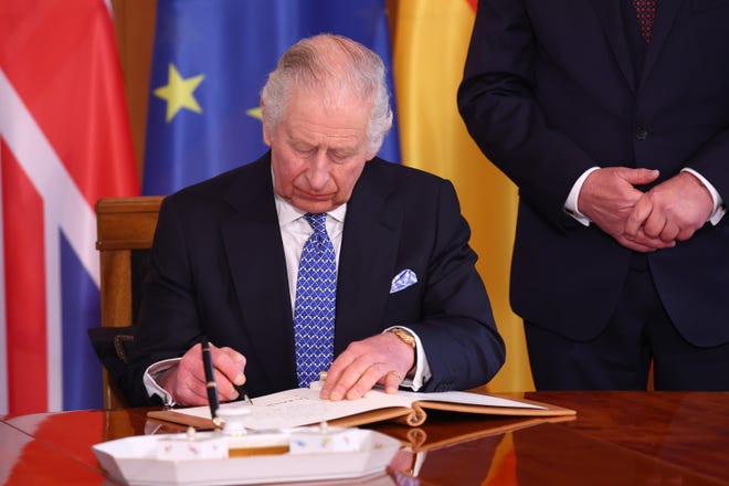 King Charles III signs the official guest book at Schloss Bellevue presidential palace on the first day of the state visit to Germany on March 29, 2023.