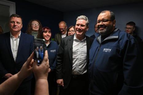 Keir Starmer posing for selfies with staff during a visit to the Burts crisp factory in Plymouth today.
