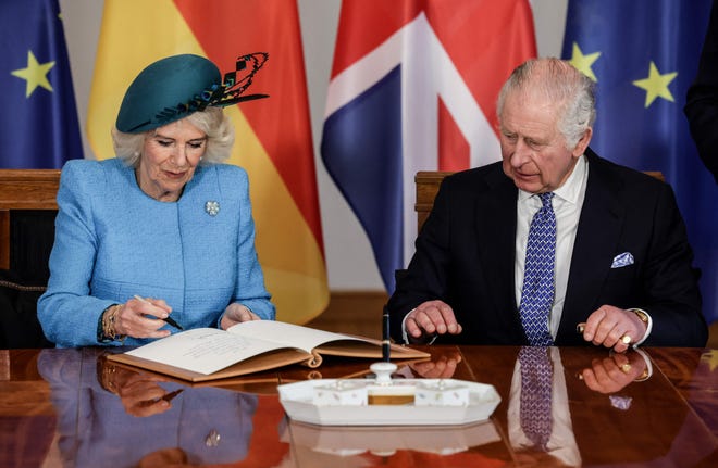 Queen Consort Camilla signs the guest book at the presidential Bellevue Palace in Berlin, on March 29, 2023.