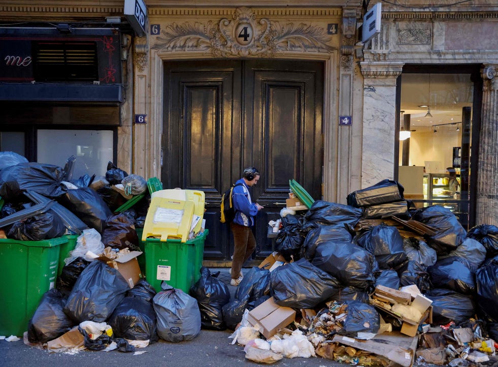 March 20, 2023: A man walks past a pile of garbage bags that have been piling up since waste collectors went on strike against the French government's proposed pensions reform, in Paris.