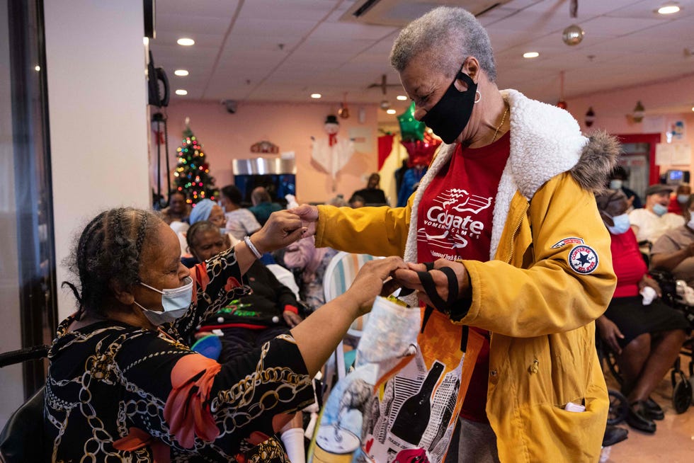 A nursing home resident and a visitor dance together during the residents' Christmas party at Crown Heights Center for Nursing and Rehabilitation in Brooklyn, New York in December 2021.