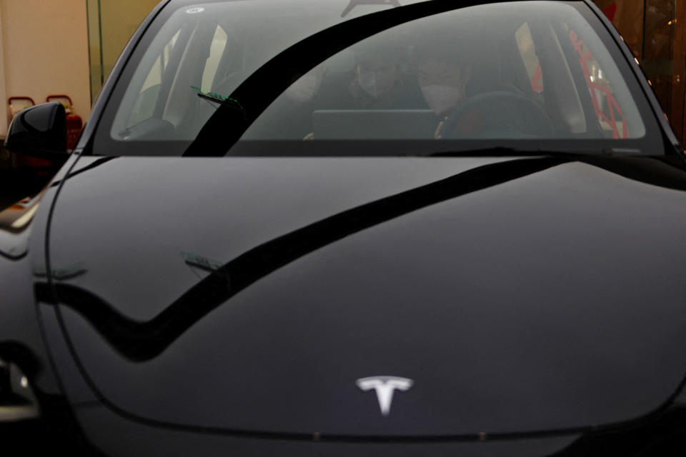 A staff member attends to customers inside a Tesla Model Y car at a showroom of the U.S. electric vehicle (EV) maker in Beijing, China February 4, 2023. REUTERS/Florence Lo