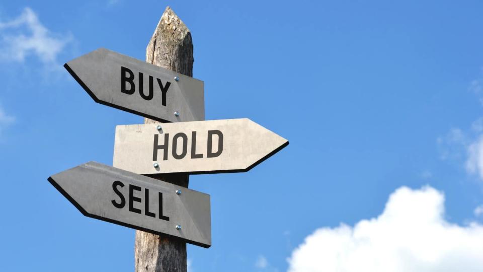 Three signposts pointing in different directions, with &#39;Buy&#39; &#39;Sell&#39; and &#39;Hold&#39; on