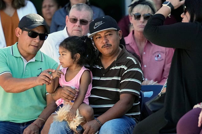 Mass shooting survivor Wilson Garcia, center, holds a young girl during a vigil for his son Daniel Enrique Laso, 9, Sunday, April 30, 2023, in Cleveland, Texas.