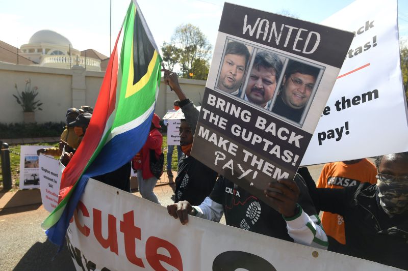 A group of people protest  outside the United Arab Emirates' embassy calling for the speedy extradition of the Guptas on June 10, in Pretoria, South Africa.