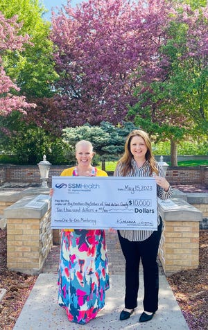 Katherine Vergos (right), SSM Health St. Agnes Hospital president, presents a $10,000 donation to Tammy Young, Big Brothers Big Sisters of Fond du Lac executive director.