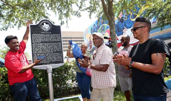 Sam Collins III, left, and others celebrate at the Juneteenth historical marker on June 17, 2021, in Galveston, Texas, after President Joe Biden signed the Juneteenth National Independence Day Act into law. Communities all over the country will be marking Juneteenth, the day that enslaved Black Americans learned they were free. For generations, the end of one of the darkest chapters in U.S. history has been recognized with joy in the form of parades, street festivals, musical performances or cookouts. Yet, the U.S. government was slow to embrace the occasion. (Jennifer Reynolds/The Galveston County Daily News via AP, File)
