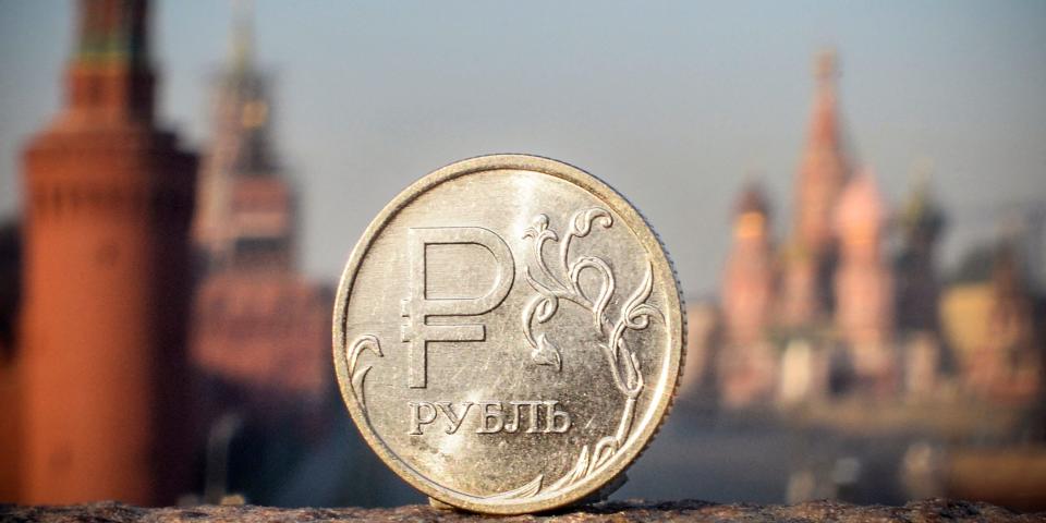 A Russian ruble coin is pictured in front of the Kremlin in central Moscow, on April 28, 2022.