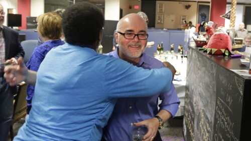 FILE - Charlotte Observer editorial cartoonist Kevin Siers, right, gets a hug from a co-worker as the newsroom as they celebrate Siers winning the Pulitzer Prize for Editorial Cartooning at the newspaper in Charlotte, N.C., on Monday, April 14, 2014. Siers was among three Pulitzer Prize-winning editorial cartoonists who were laid off last week. (AP Photo/Chuck Burton, File)