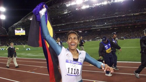 FILE - In this Sept. 25, 2000, file photo, Australia's Cathy Freeman celebrates winning the women's 400 meter race at the Summer Olympics at Olympic Stadium in Sydney. Tony Gustavsson, head coach of Australia's national women's soccer team, called a meeting. Instead of leading the team through a tactical discussion, he told the players he had different plans for the evening."They played about a three-minute highlight reel on YouTube of the moment of Cathy Freeman's race," Matildas defender Aivi Luik said. "And by the end of it, there was a lot of emotion going around in the room. (AP Photo/Thomas Kienzle, File)