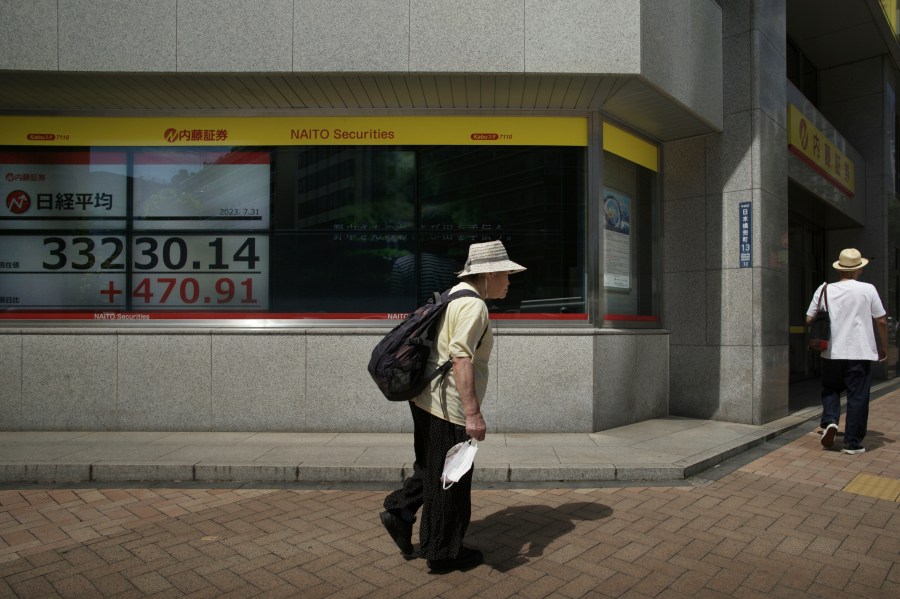 People walk by monitors showing Japan's Nikkei 225 index at a securities firm in Tokyo, Monday, July 31, 2023. Shares were mostly higher in Asia on Monday after Wall Street got back to climbing following more encouraging profit reports and the latest signal that inflation is loosening its chokehold on the economy.(AP Photo/Hiro Komae)