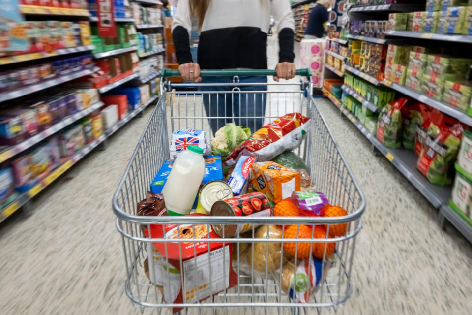 CARDIFF, WALES - MAY 22: A woman with a shopping trolley full of groceries in a supermarket aisle on May 22, 2022 in Cardiff, Wales. Last week, the UK Office for National Statistics reported an 6% average increase of food and drink prices year on year, but some staples, such as milk and pasta, had risen by more than 10%. (Photo by Matthew Horwood/Getty Images)