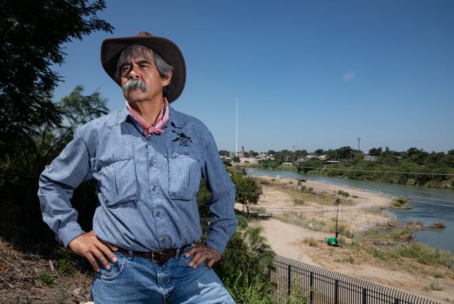 Eagle Pass native Jessie Fuentes, owner of Epi’s Canoe and Kayak, stand in front of a militarized area of the Rio Grande on Thursday, July 20, 2023, in Eagle Pass, Texas. Fuentes said an area between the shoreline and an island was filled in for vehicular access and covered in razor wire. 