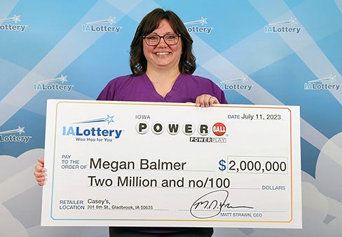 Megan Balmer of Tama County accepts her $2 million lottery prize at the Iowa Lottery headquarters in Clive on Tuesday July 11, 2023.