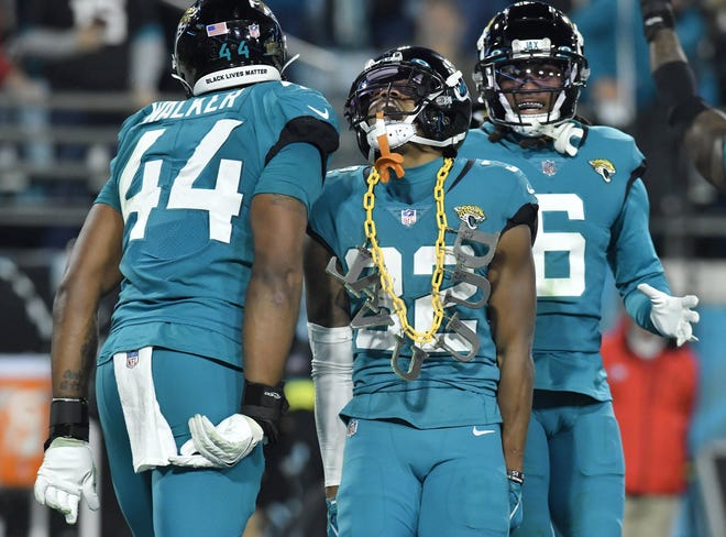 Jacksonville Jaguars cornerback Tyson Campbell (32) celebrates with teammates and a DUVAL chain from a fan in the stands after his late third quarter interception. The Jacksonville Jaguars hosted the Tennessee Titans to decide the AFC South championship at TIAA Bank Field in Jacksonville, FL, Saturday, January 7, 2023. The Jaguars went into the half trailing 7 to 13 but came back to win with a final score of 20 to 16. [Bob Self/Florida Times-Union]