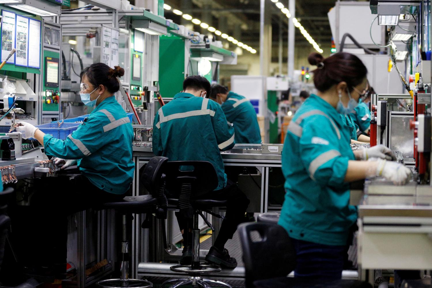 Employees work on a production line during an organised media tour to a Schneider Electric factory in Beijing. (Photo: Reuters)