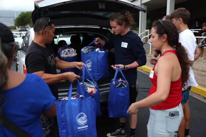 Volunteers with King's Cathedral Maui help unload a donation of supplies on Aug. 10, 2023, in Kahului, Hawaii. Dozens of people were killed and thousands displaced after a wind-driven wildfire devastated the town of Lahaina on Tuesday. King's Cathedral Maui is providing food and shelter for displaced families.