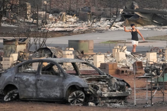 A young boy walks through wildfire wreckage Thursday, Aug. 10, 2023, in Lahaina, Hawaii. The search of the wildfire wreckage on the Hawaiian island of Maui on Thursday revealed a wasteland of burned out homes and obliterated communities as firefighters battled the stubborn blaze making it the deadliest in the U.S. in recent years.