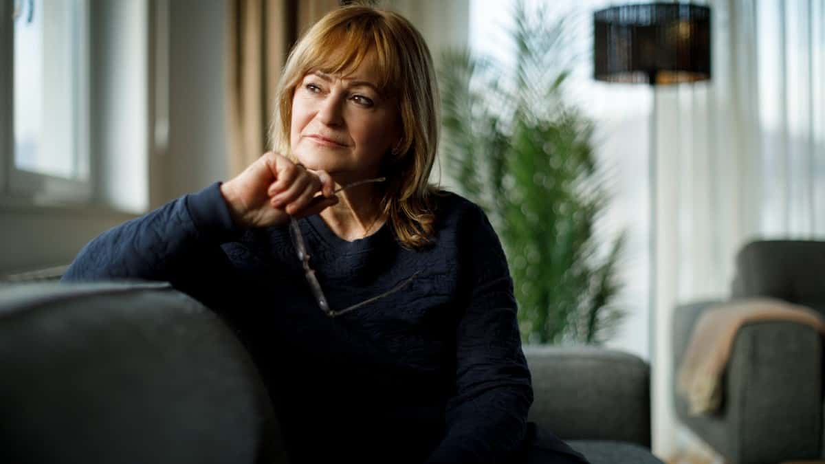 Middle-aged Caucasian woman deep in thought while looking out of the window