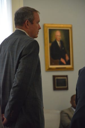 Convicted and disgraced Hampton banker Russell Laffitte stands in the Hampton County Courthouse as, in the background, hangs a portrait of Alex Murdaugh's grandfather, Randolph "Buster" Murdaugh Jr.
