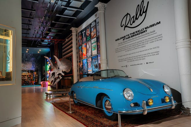 A 1955 Porsche Speedster with a 60 million-year-old Triceratops skull fossil in the background on display at The Rally Museum in New York City.