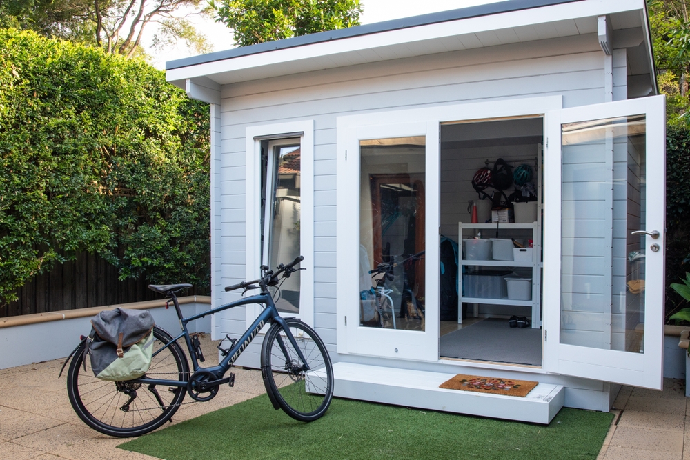 Image of an outside garden shed transformed into a storage space with a bike outside