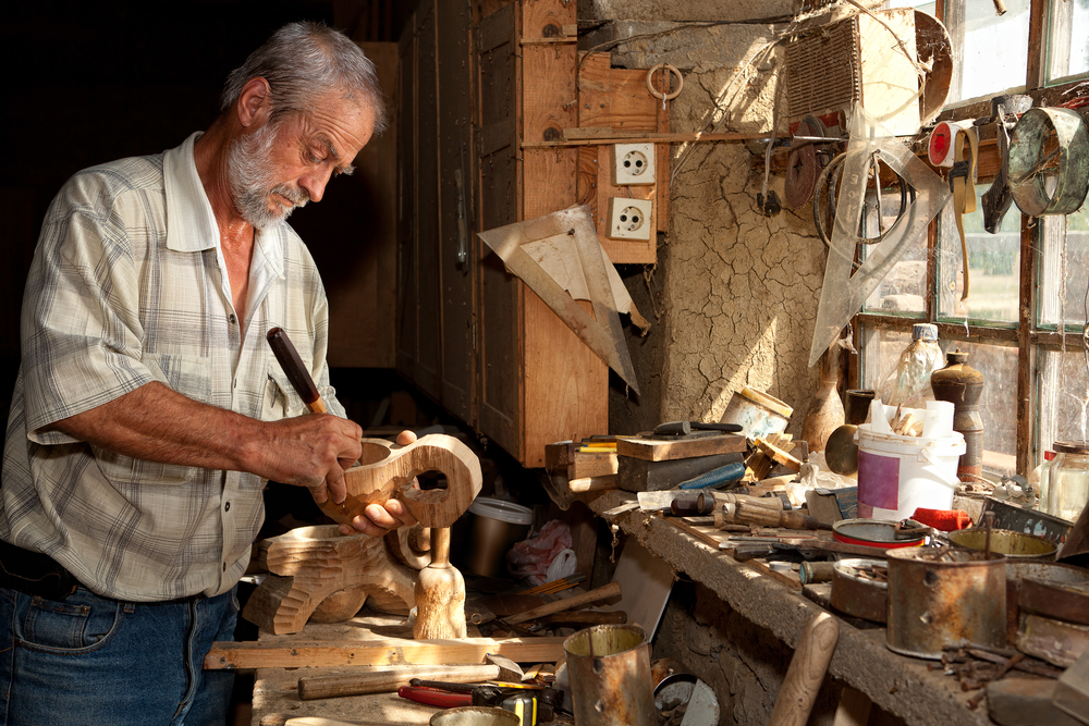 Image of a man working with tools and wood inside a shed