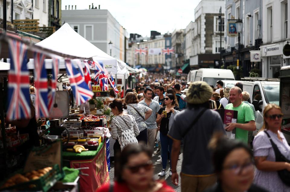 FTSE People walk past stalls at Portobello Road Market in west London on August 19, 2023. (Photo by HENRY NICHOLLS / AFP) (Photo by HENRY NICHOLLS/AFP via Getty Images)