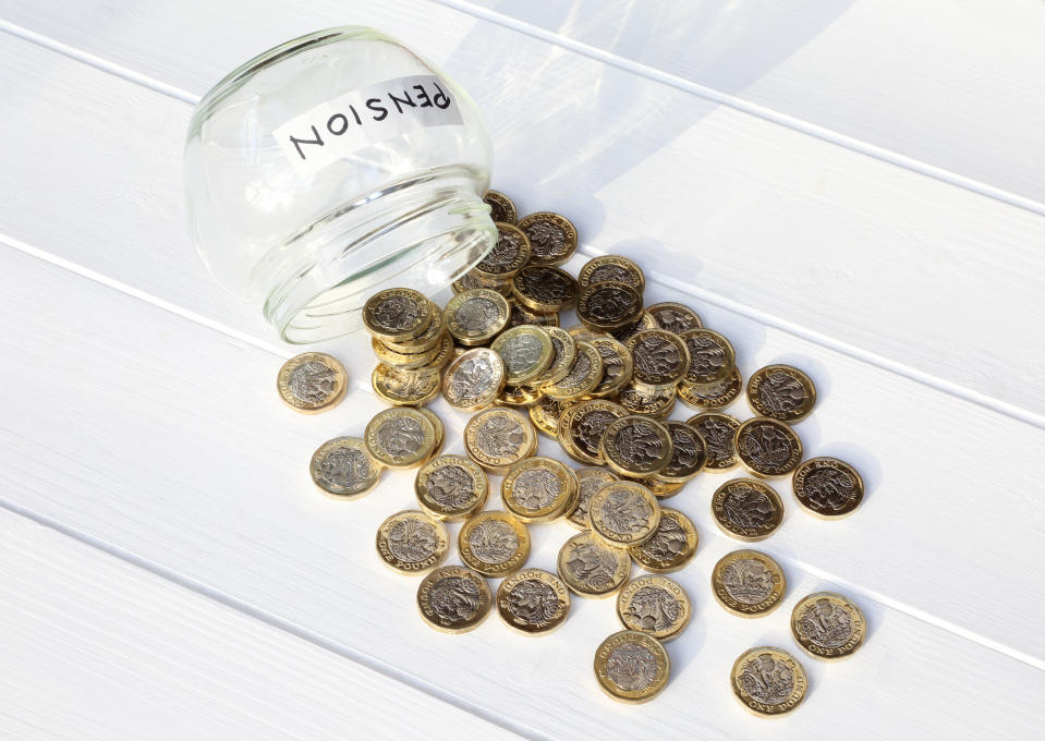 One pound coins spilling out of an upturned  jar marked 'Pension' illustrating the withdrawal and spending of an entire pension leaving no resources.