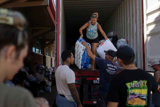 Volunteers unload donated goods at a food and supply distribution center in Lahaina, Hawaii, on Aug. 17, 2023.