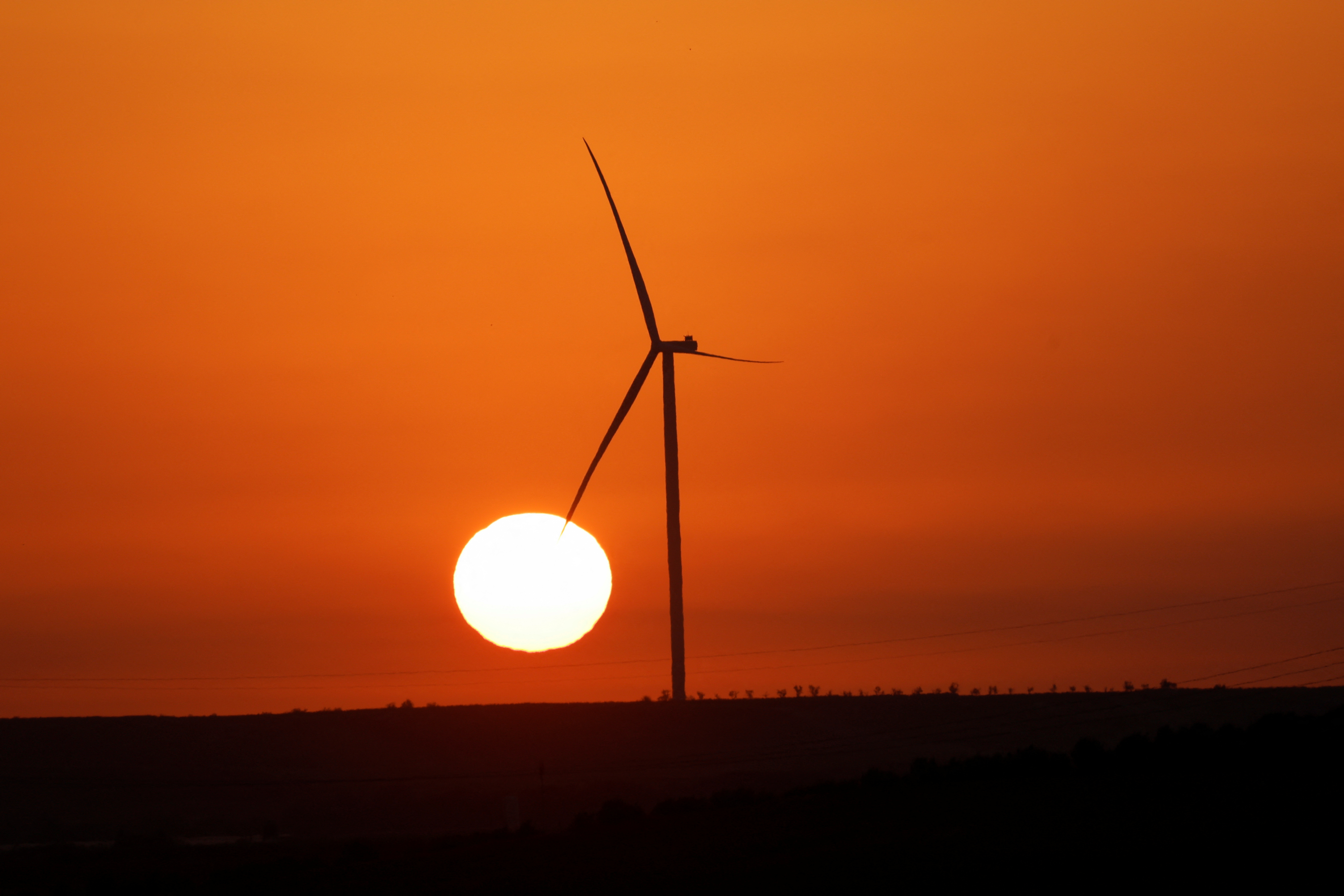 The sun rises behind a wind turbine near Zaragoza