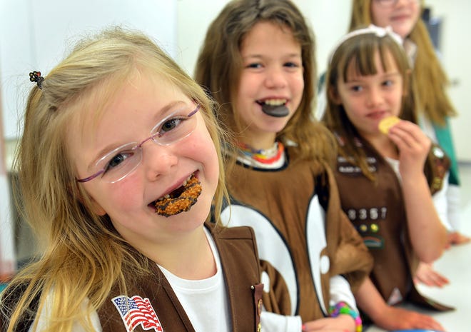 Not such sweet news: Girl Scout cookies prices are going up. In this Jan. 3, 2014, photo, Bellas Simmons, 8, left, her sister Callie, 10, and Danielle Thor, 9, all of Cross Lanes, W.Va., pose for a photo in Charleston, W.Va, after the Girls Scouts kicked off their annual cookie sale fundraiser with some taste testing.