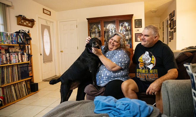 Lehigh Acres residents, Michael and Colleen Barineau sit for a portrait with their dog Bo on Wednesday, Oct. 11, 2023.