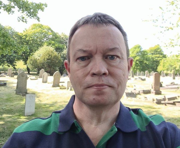 Julian Price looks at the camera from a graveyard 