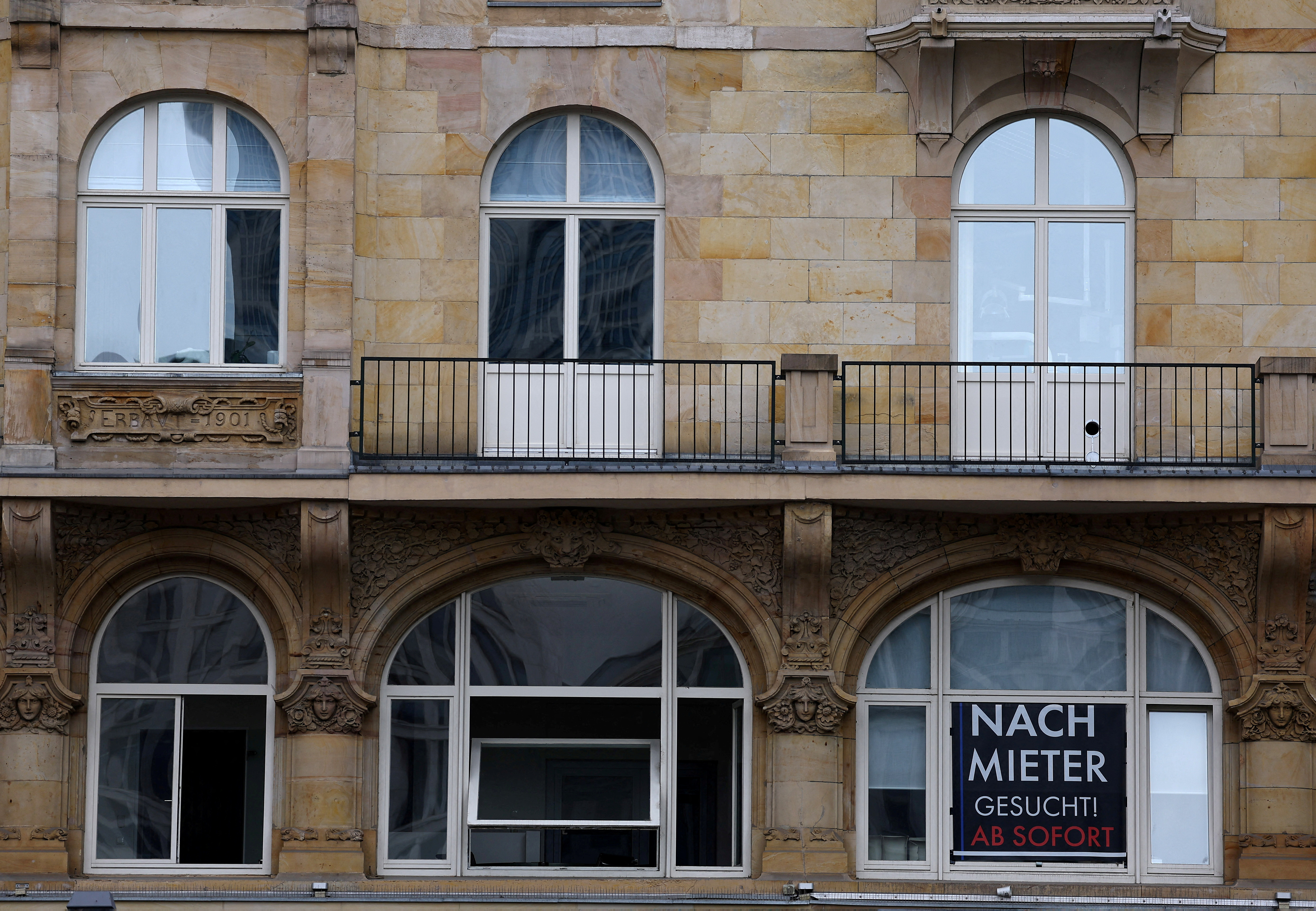 A sign reads "new tenant wanted" in a window of a commercial building in Frankfurt