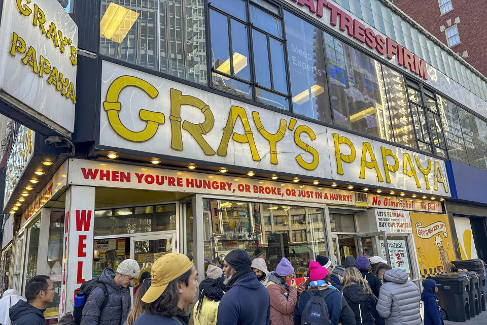 File - People crowd the front of a Gray's Papaya hot dog and fruit juice restaurant in New York on Nov. 23, 2023. Confidence is growing among Federal Reserve officials and many economists that high interest rates and healed supply chains will soon defeat inflation. (AP Photo/Ted Shaffrey)