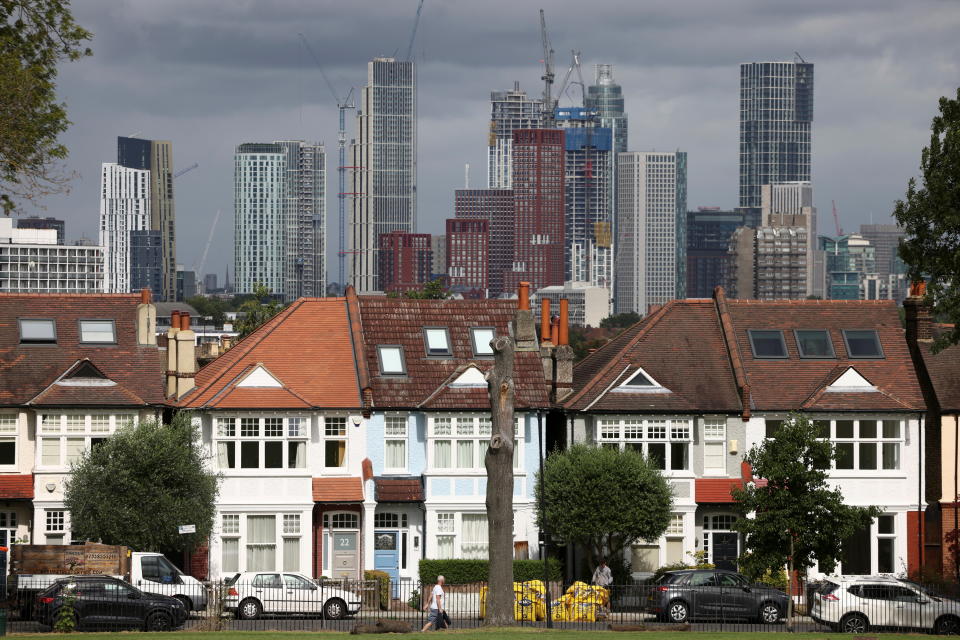 High-rise apartments under construction can be seen in the distance behind a row of residential housing in south London, Britain, August 6, 2021. REUTERS/Henry Nicholls